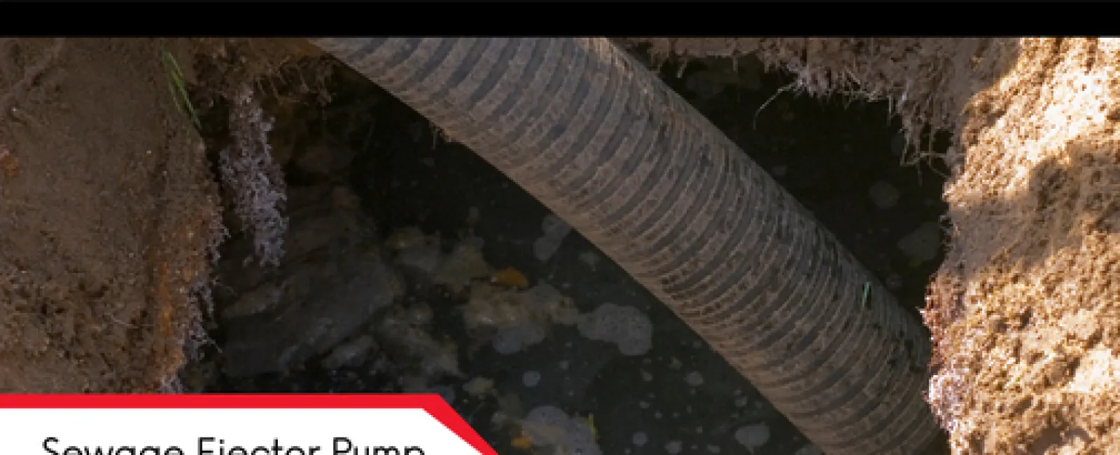 Close-up of a sewage ejector pump pipe in muddy water surrounded by soil and debris.