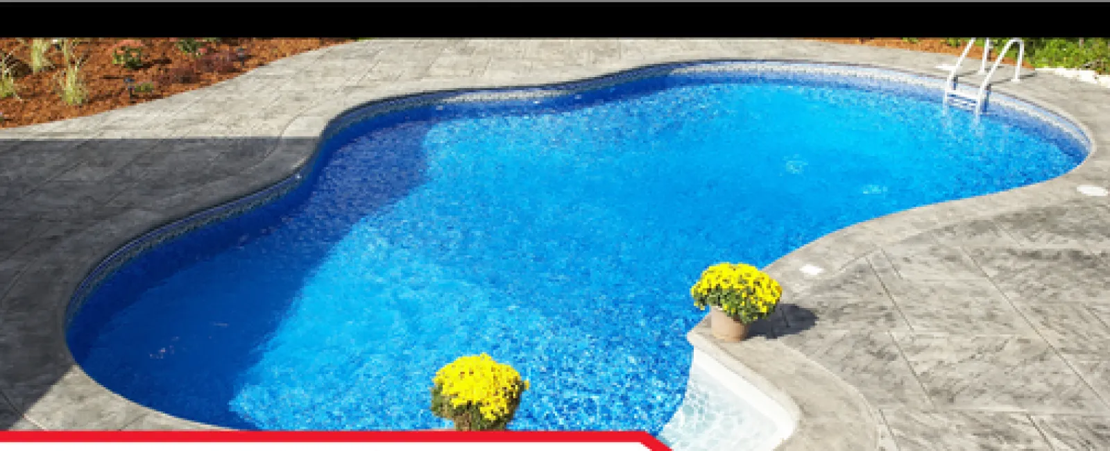 Blue swimming pool with stamped concrete deck and yellow flowers near the retaining wall inspection area.