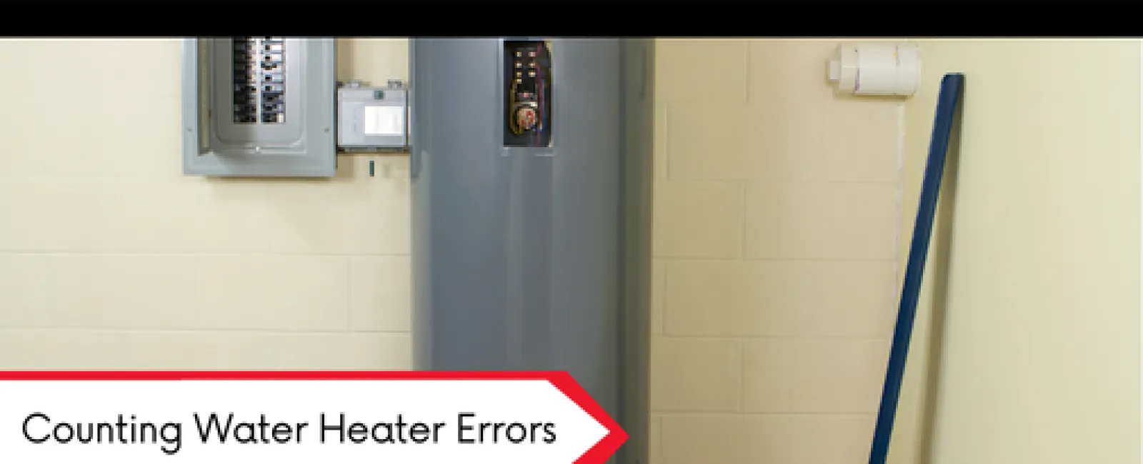 Modern gray water heater with electrical panel and toolbox in a clean utility room with beige walls.