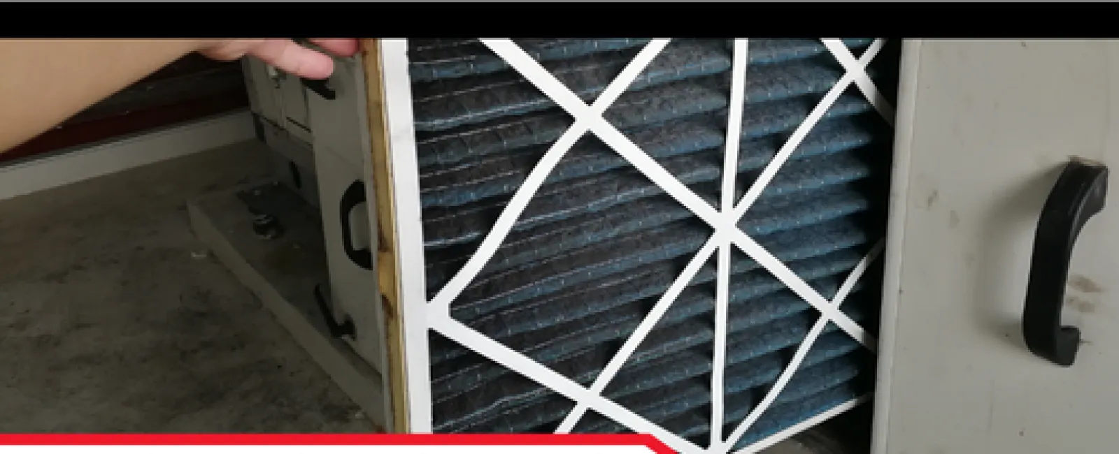 Hand inspecting a dirty air filter in an attic HVAC unit during an inspection report.