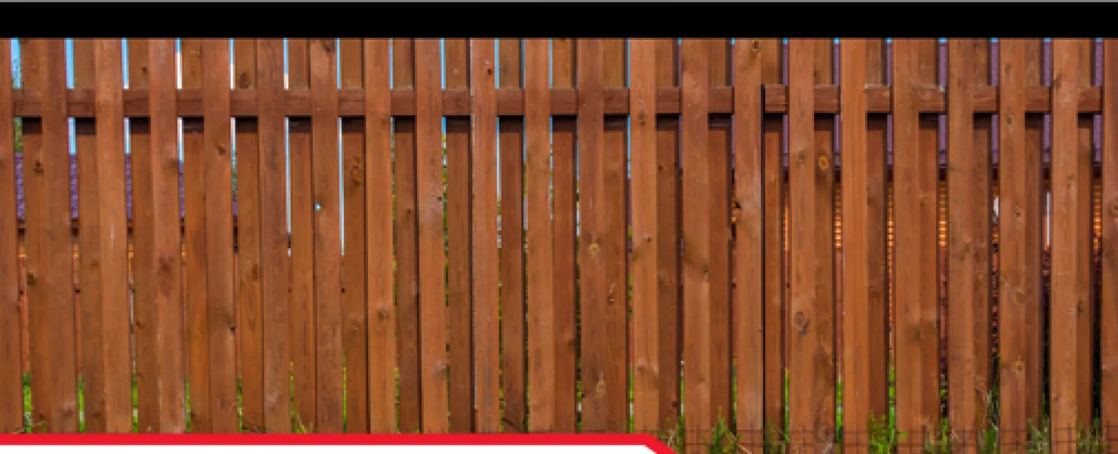 Wooden fence with green grass and text about uncovering termite activity by a certified inspector.