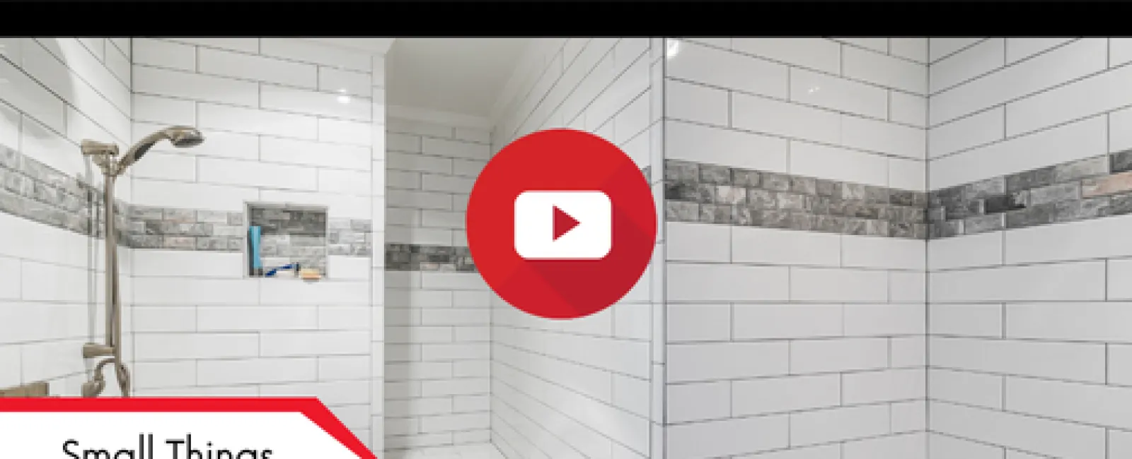 White tiled shower with gray mosaic border and built-in bench under soft lighting