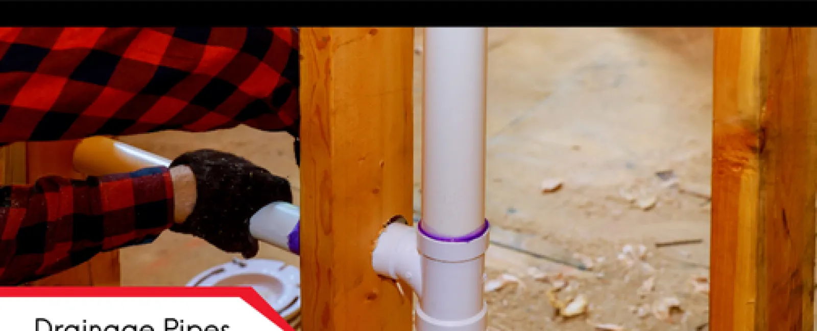 Handyman installing white drainage pipes through wooden framing with purple primer applied on joints indoors.
