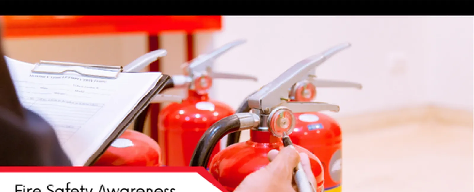 Person inspecting red fire extinguishers while holding clipboard for fire safety awareness training.