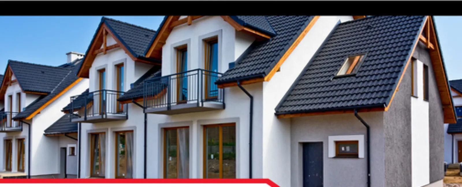 Modern newly constructed houses with gabled roofs and balconies under clear blue sky, showcasing exterior wall conduits.