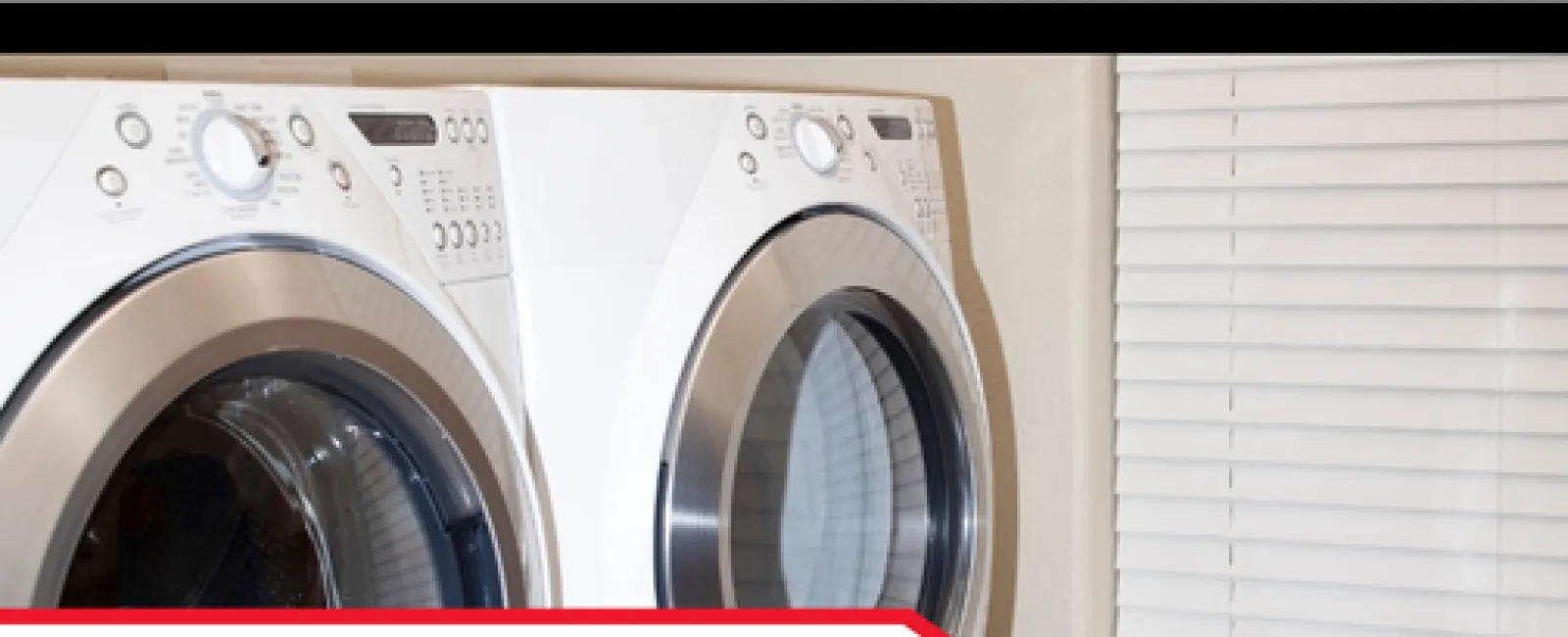 Front-load washer and dryer set beside a window with blinds in a home laundry room.