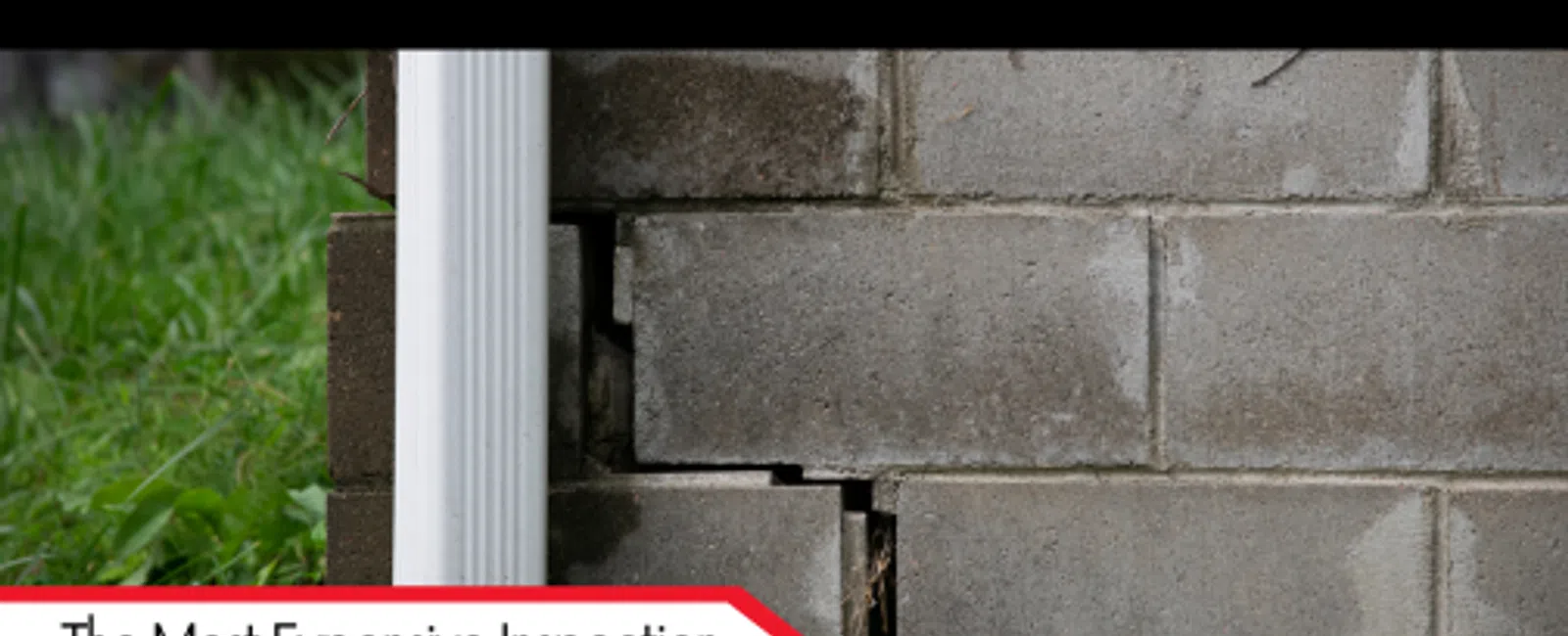 Cracked concrete block foundation near white downspout showing common inspection issue in homes.