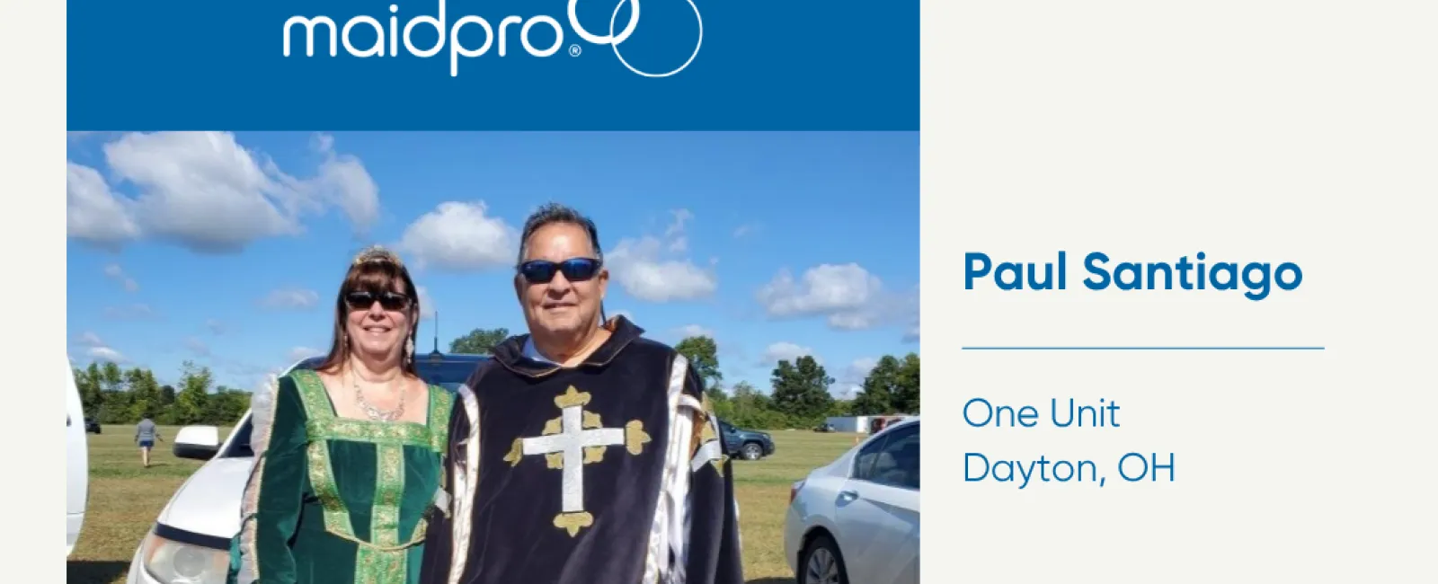 Two people in medieval costumes standing outdoors near cars under a blue sky, MaidPro franchise awarded.