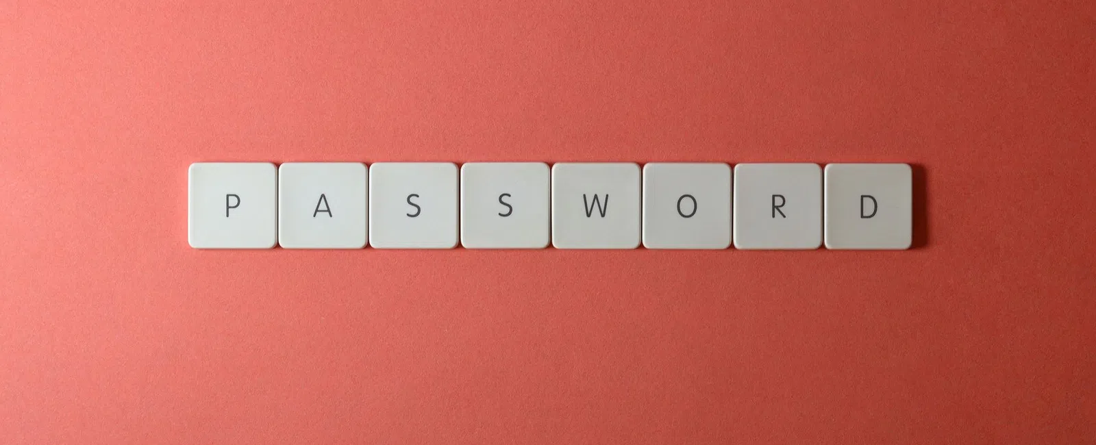 White keyboard keys spelling PASSWORD on a coral red background symbolizing security and access.