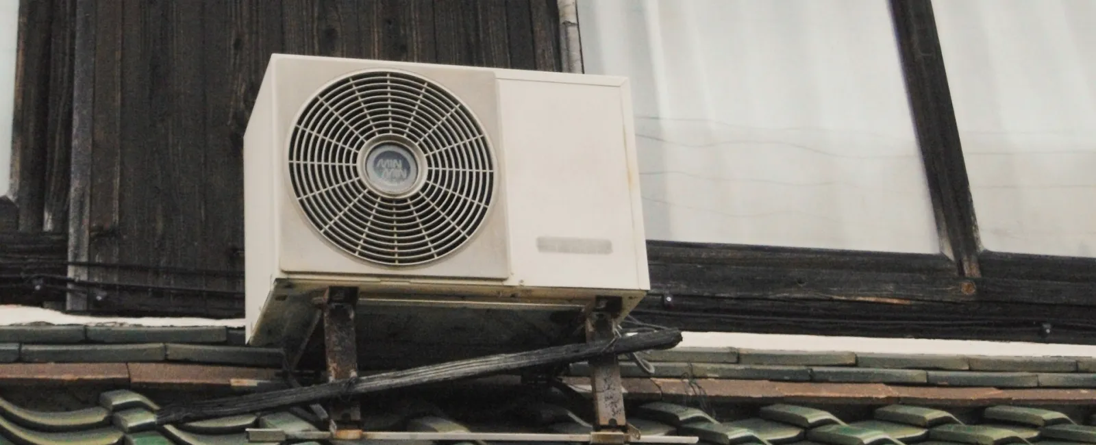 Air conditioning unit mounted on a building, showcasing a blend of modern and traditional architecture.