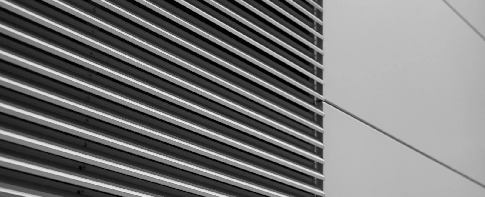 Close-up of parallel metallic lines on a modern building exterior.