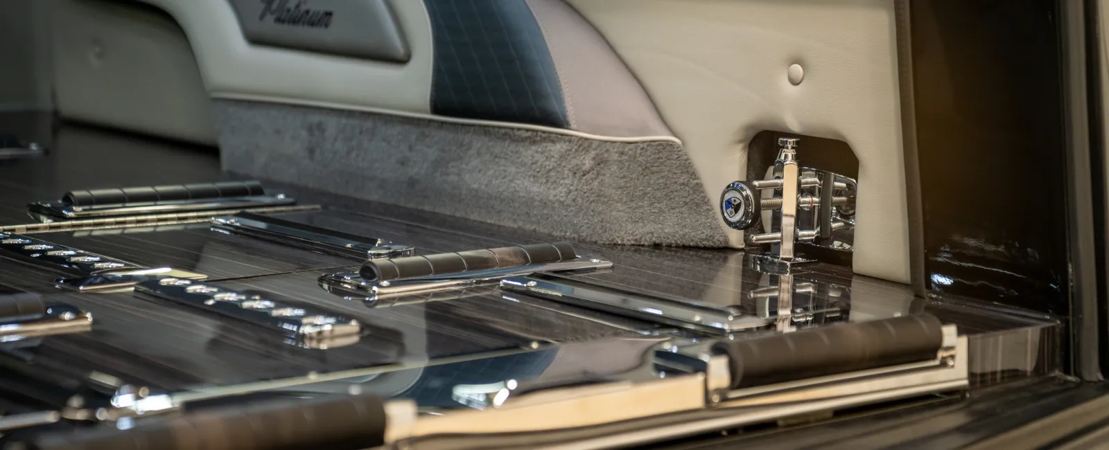 Close-up of a polished metal and leather interior panel with detailed hinges and a leather armrest, featuring the brand name Phatum.