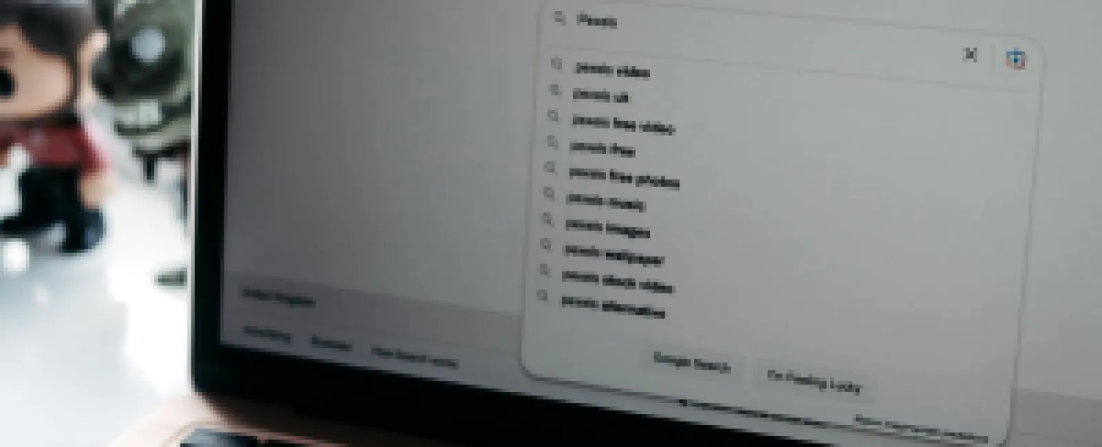 Open laptop showing Google search page with autocomplete suggestions starting with 'Press'