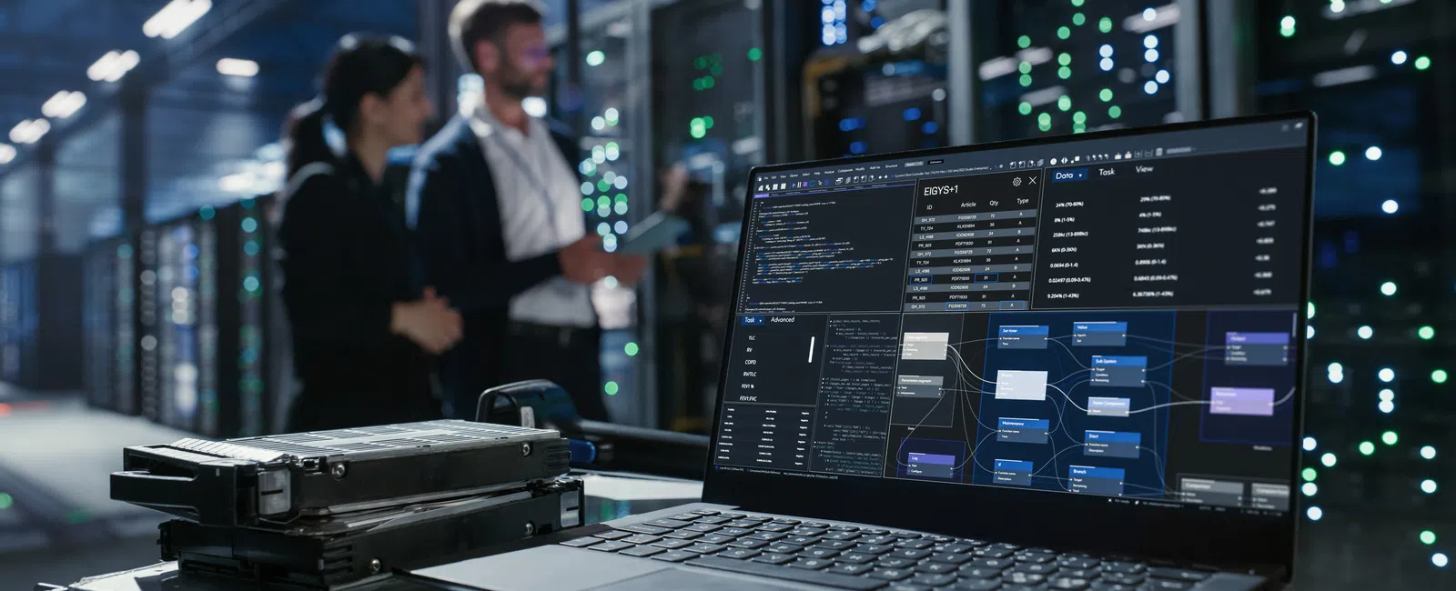 Laptop displaying complex data analytics and flowcharts in a server room with IT specialists in background.