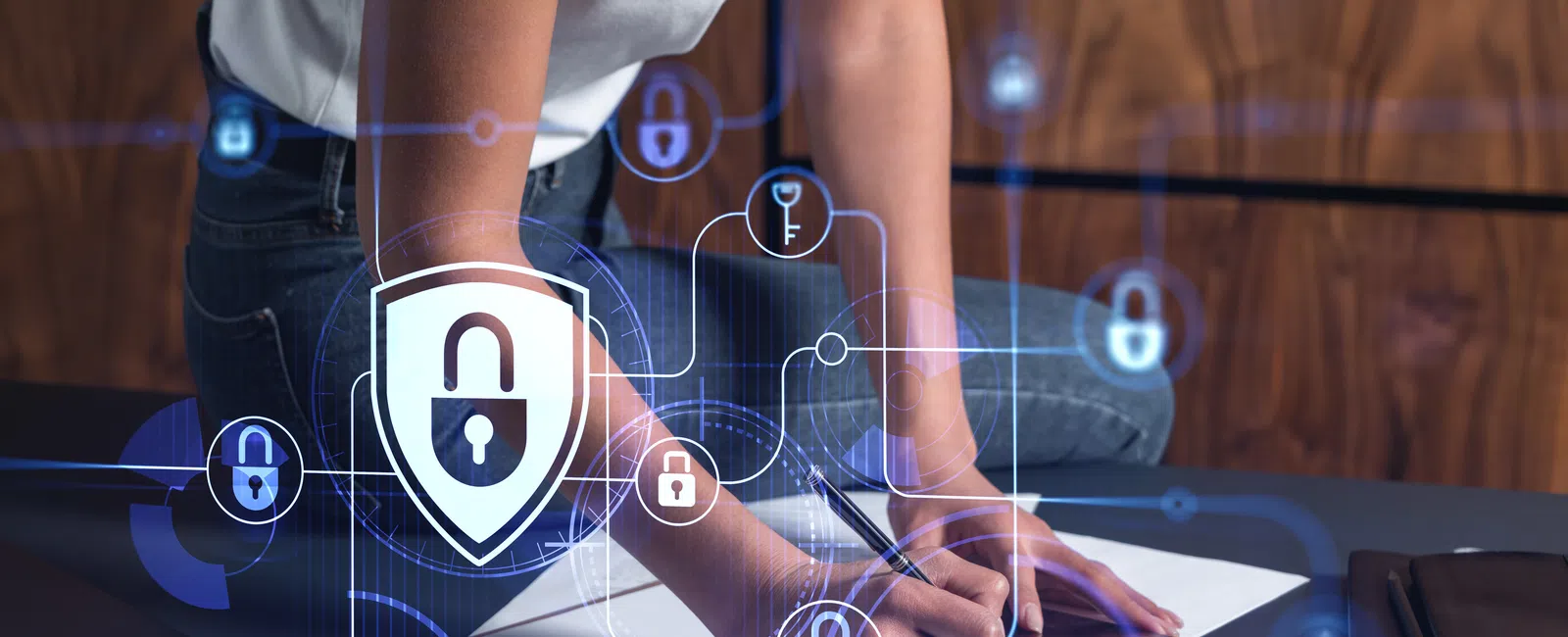 Person writing on a clipboard with digital padlock icons representing cybersecurity and data protection overlay.