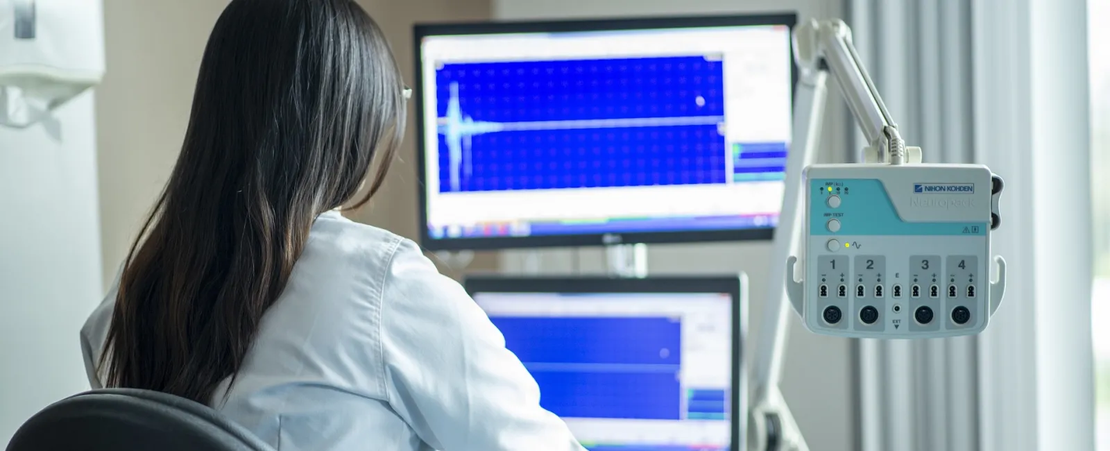 Doctor working at a computer in an exam room.