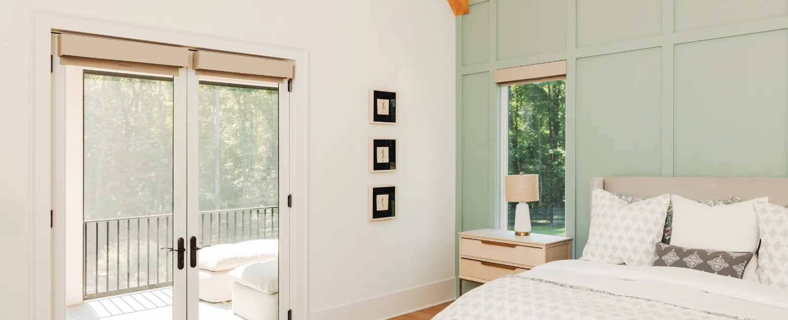 Bright modern bedroom with wooden floor, light green accent wall, large bed, and glass doors to balcony.