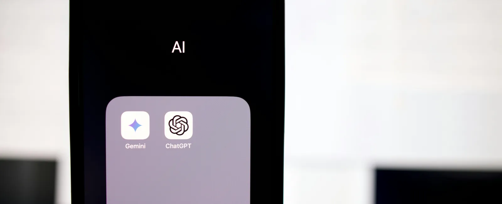Smartphone screen showing a folder labeled AI with Gemini and ChatGPT apps used for integrating AI in business