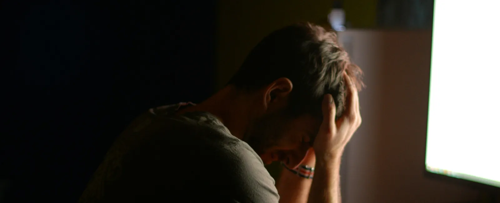 a person sitting at a desk with the head in the hand