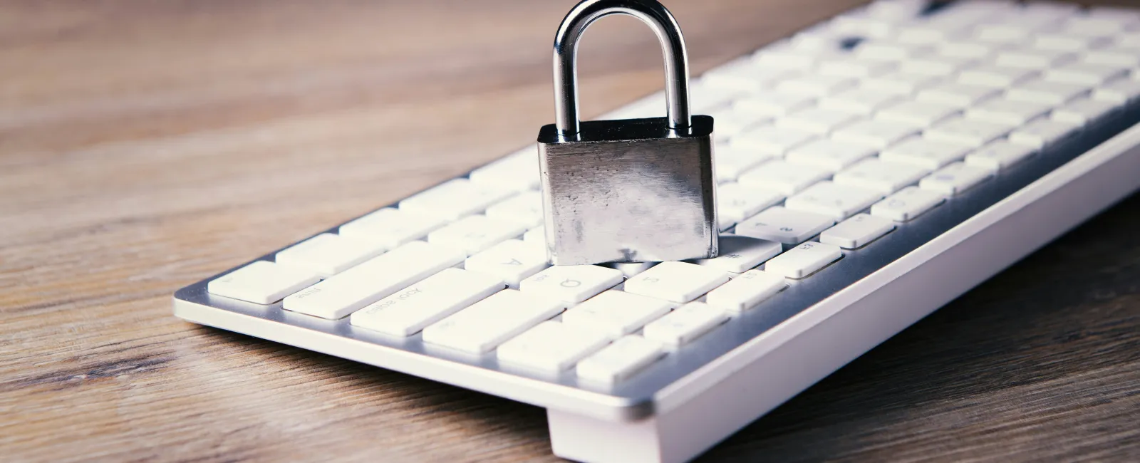 Silver padlock on a white computer keyboard symbolizing online cybersecurity and cyber security gaps