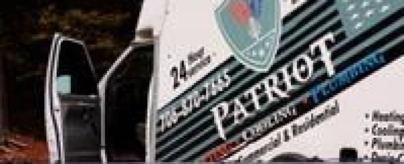 Security patrol vehicle parked with open door behind chain-link fence in an outdoor setting