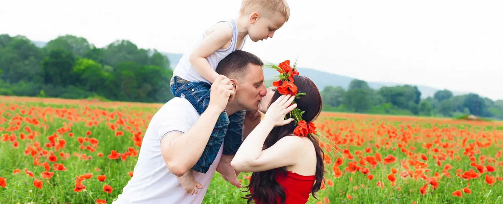 a man and woman kissing in a field of flowers