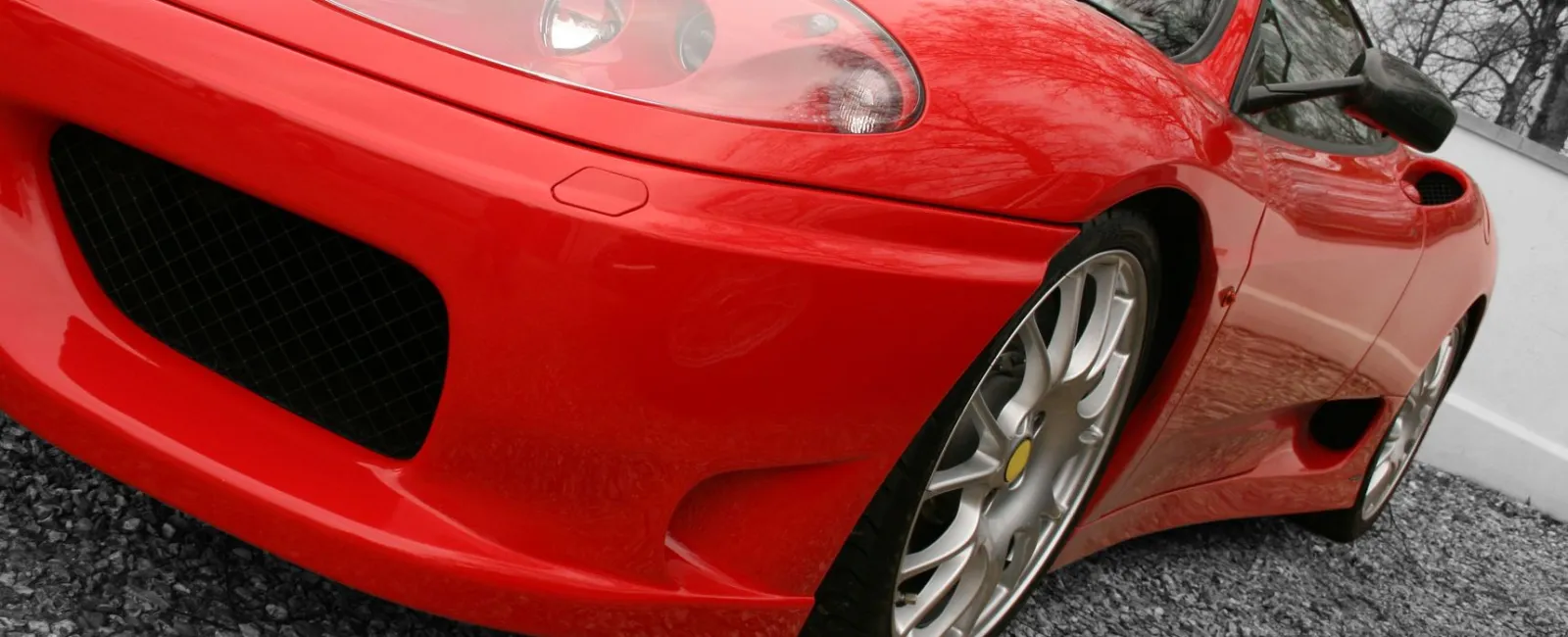 a red car parked on gravel