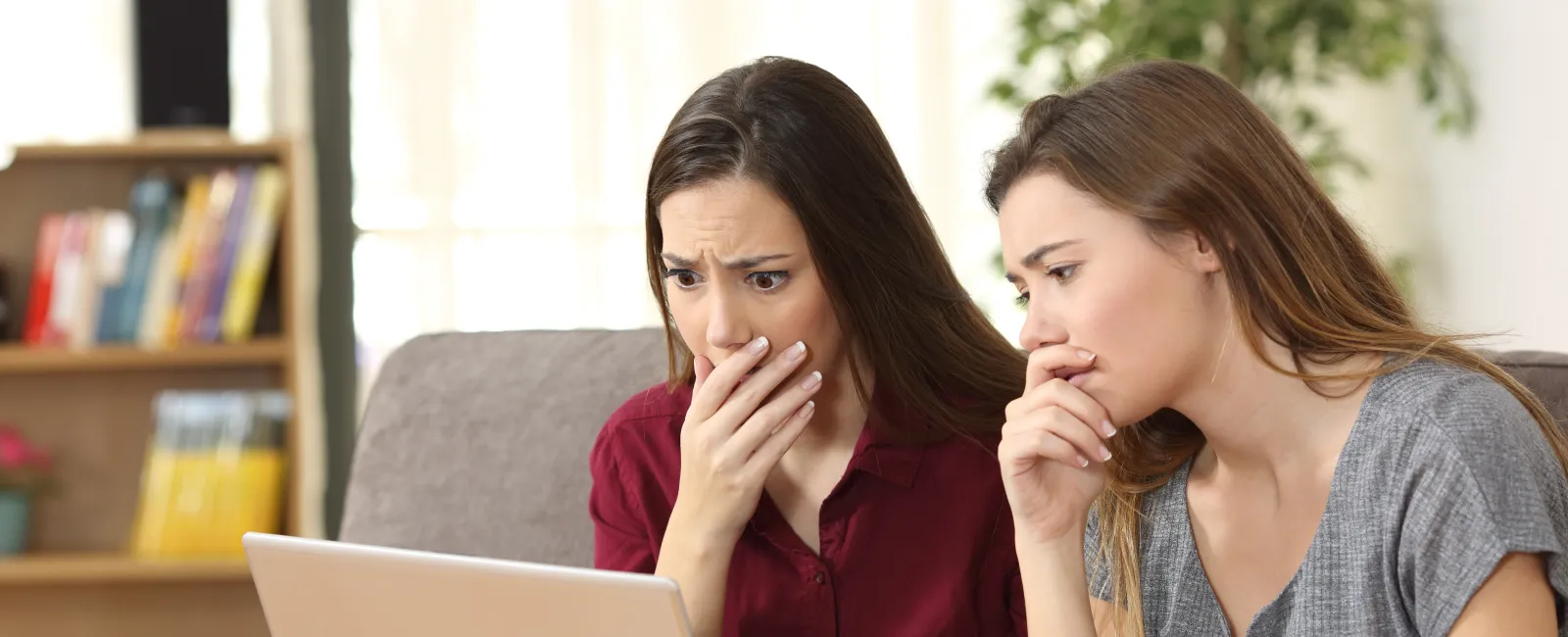 a couple of women looking at a laptop