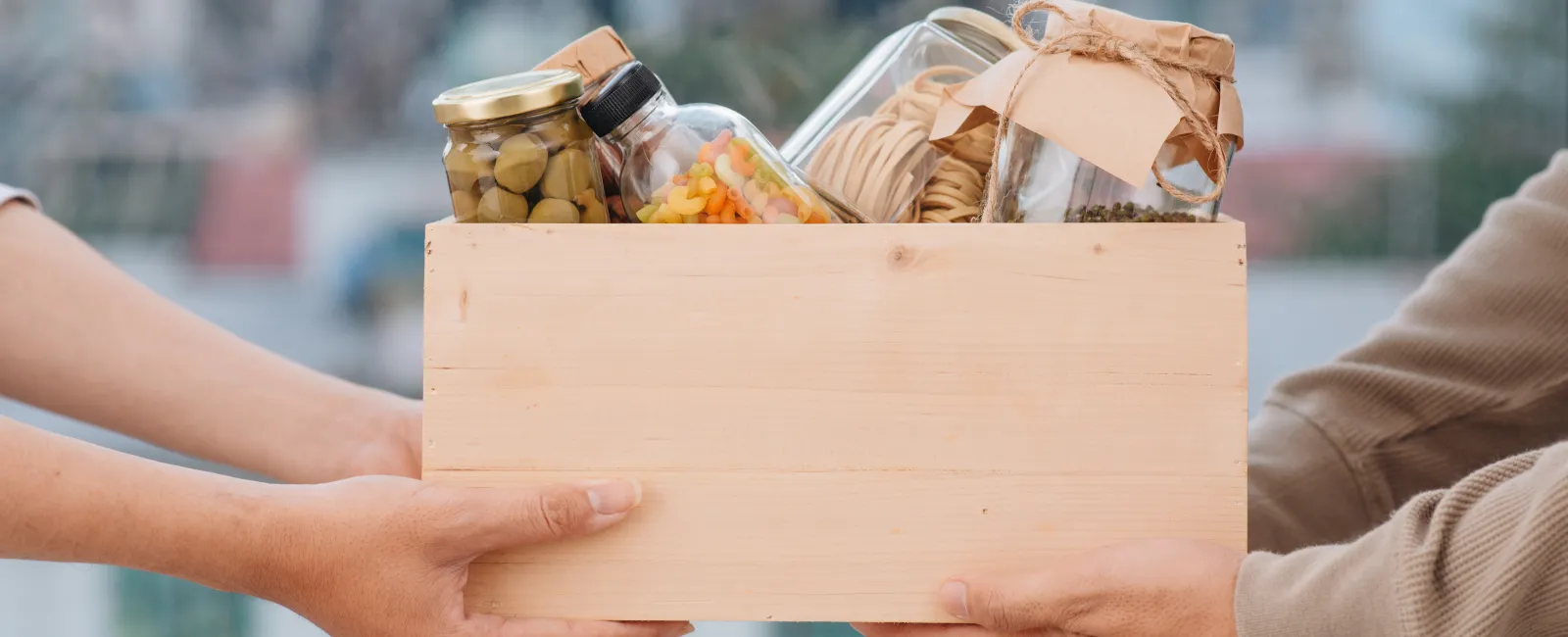 a couple of hands holding a box of donations