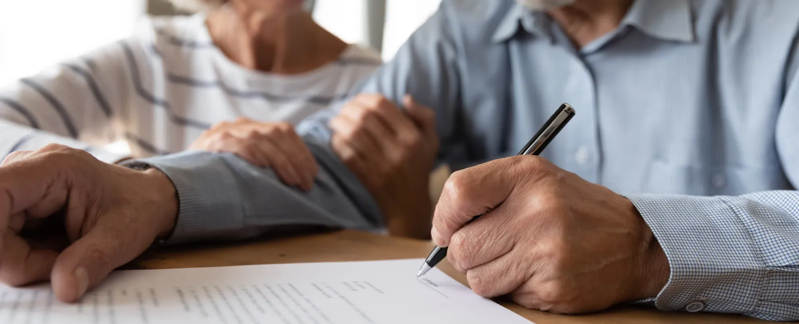 a man and a woman sitting at a table and looking at a paper