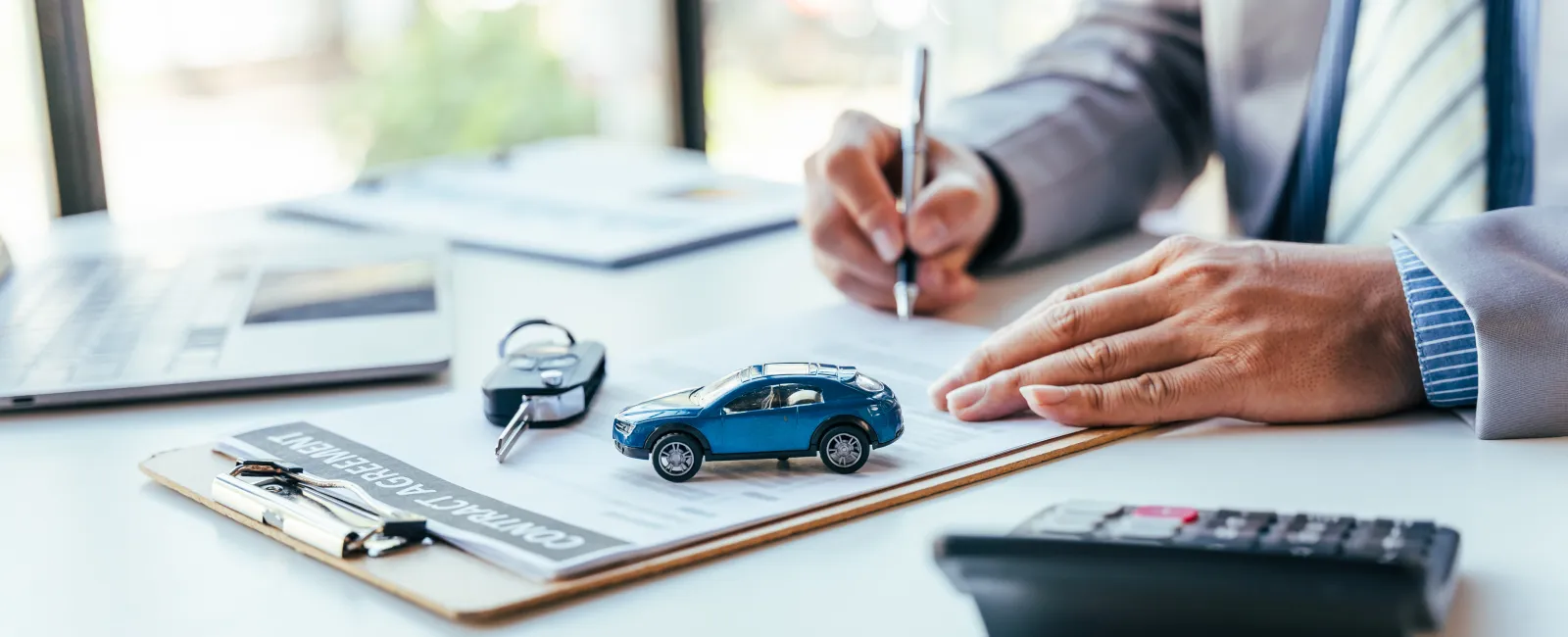 a man holding a pen and a toy car