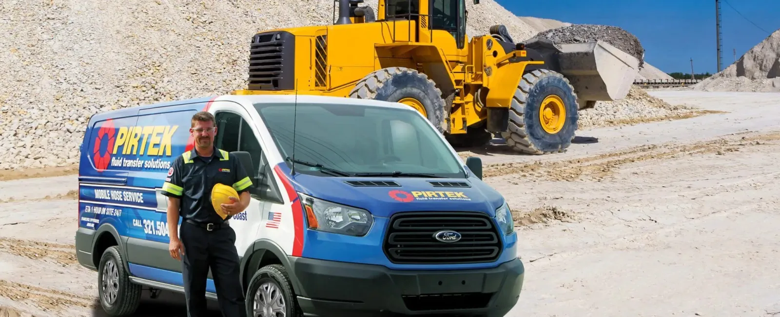 PIRTEK service van and worker with helmet in front of yellow loader at gravel site under blue sky