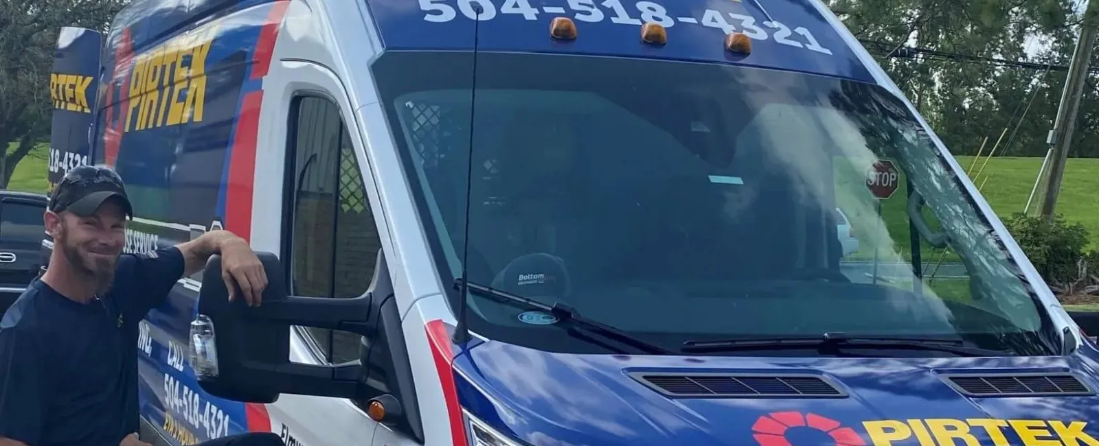 Service van with PIRTEK logo and phone number 504-518-4321 parked outdoors with a smiling worker beside it