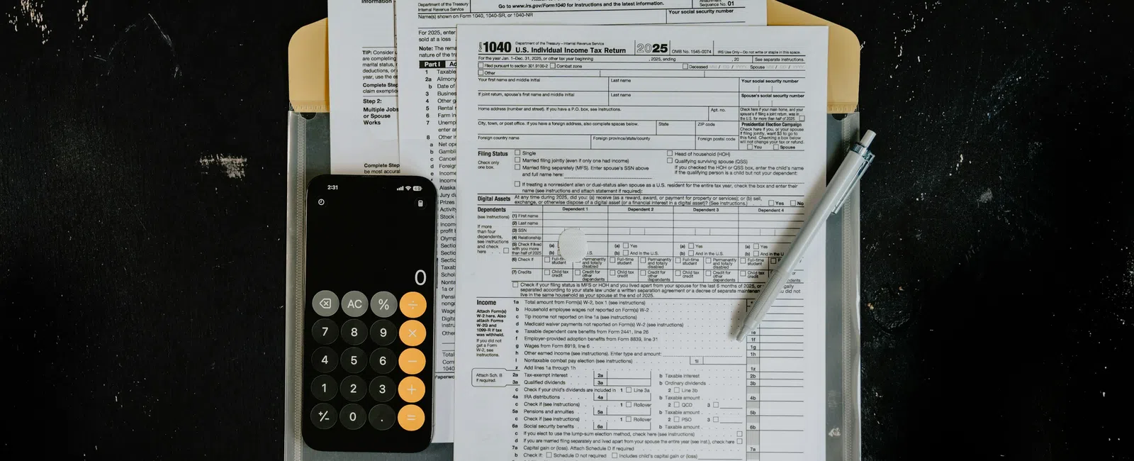 Tax forms including W-4 and 1040 with a calculator and pen on a black surface folder.