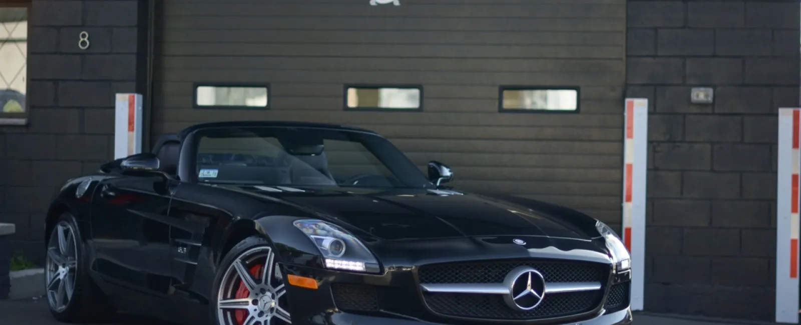 a black car parked in front of a garage