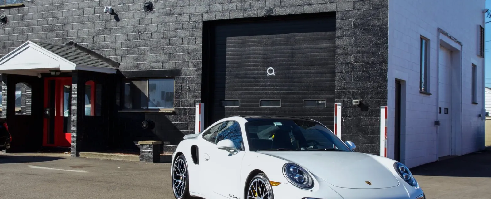 a white sports car parked in front of a building