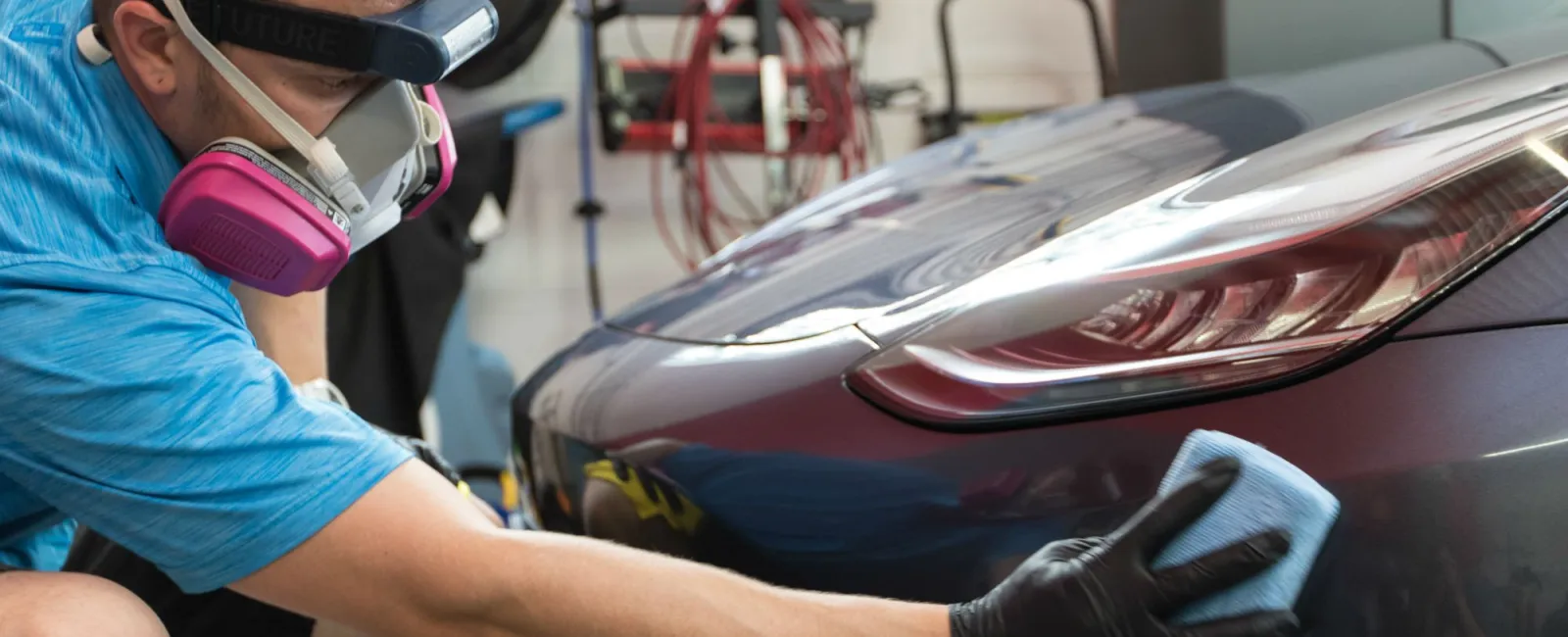 a person wearing a mask and gloves working on a car