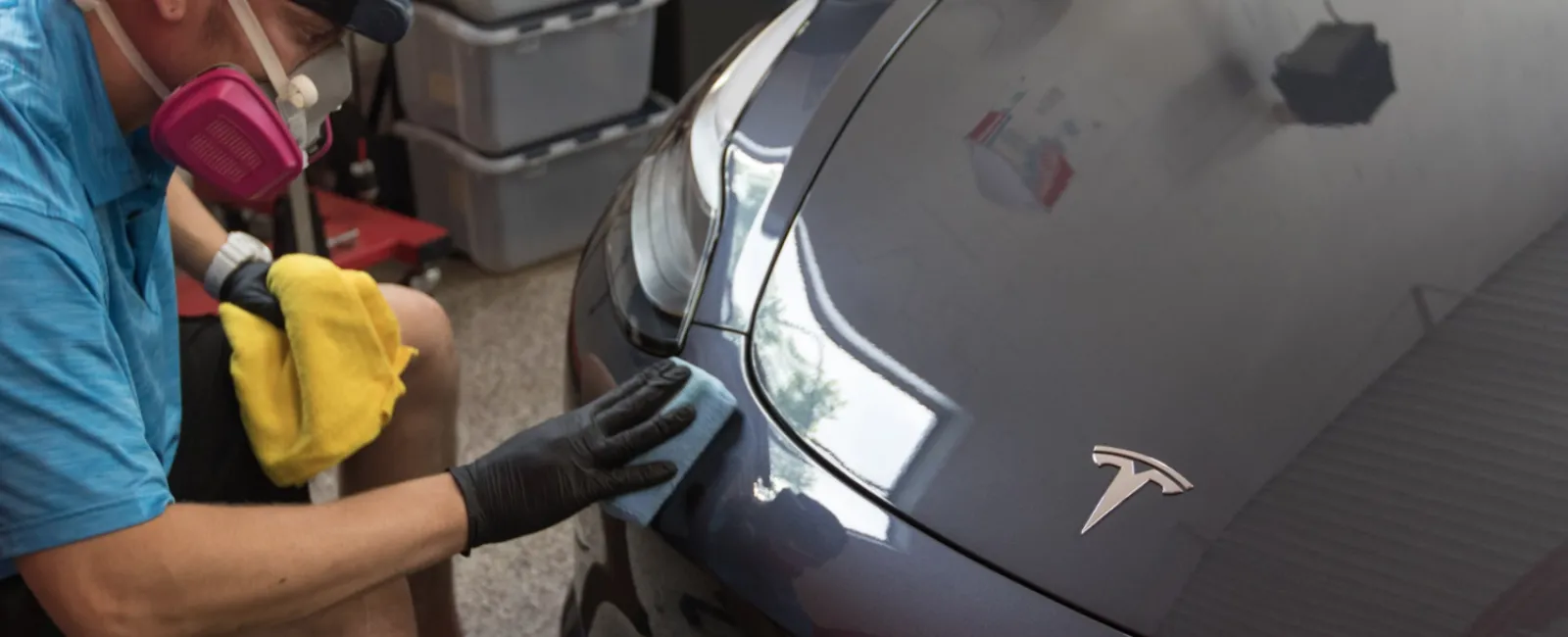 a person wearing a mask and gloves working on a car