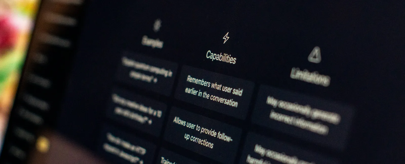 Close-up of ChatGPT interface displaying examples, capabilities, and limitations on a dark screen.