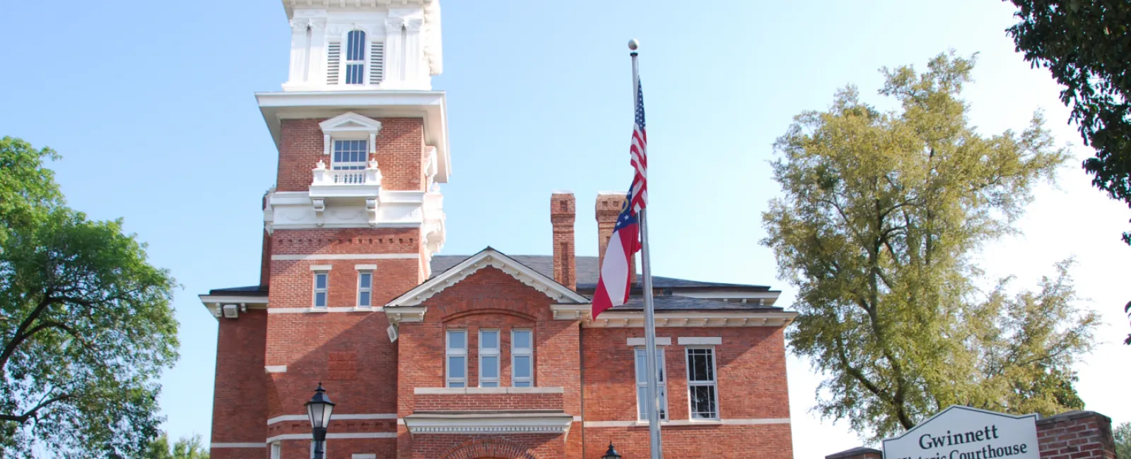 a small clock tower in front of a brick building