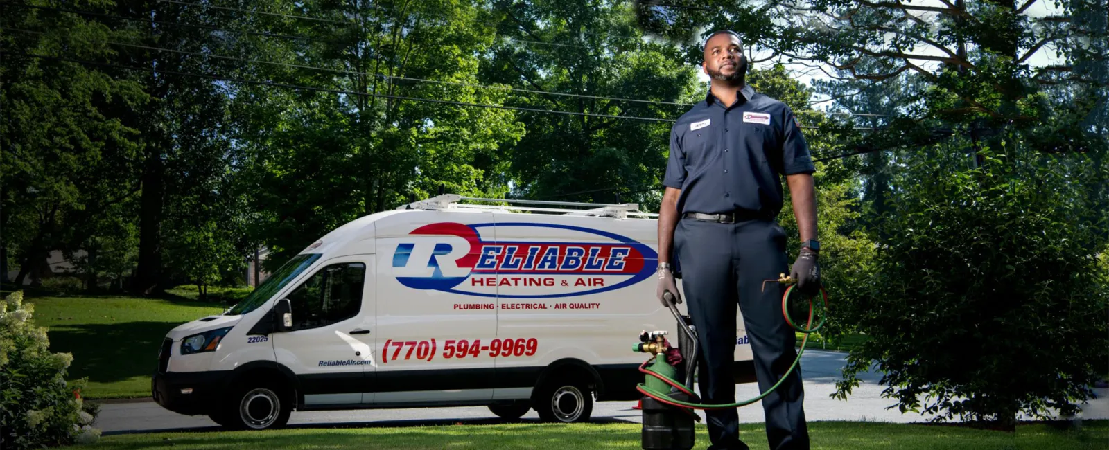 an HVAC technician standing next to a white van