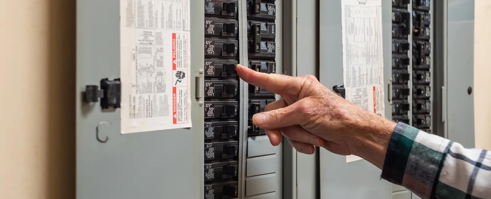 a person standing in front of a electrical panel