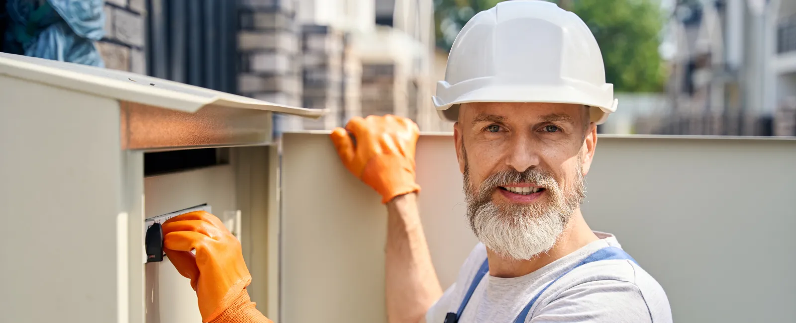 a man wearing a hard hat and holding a drill