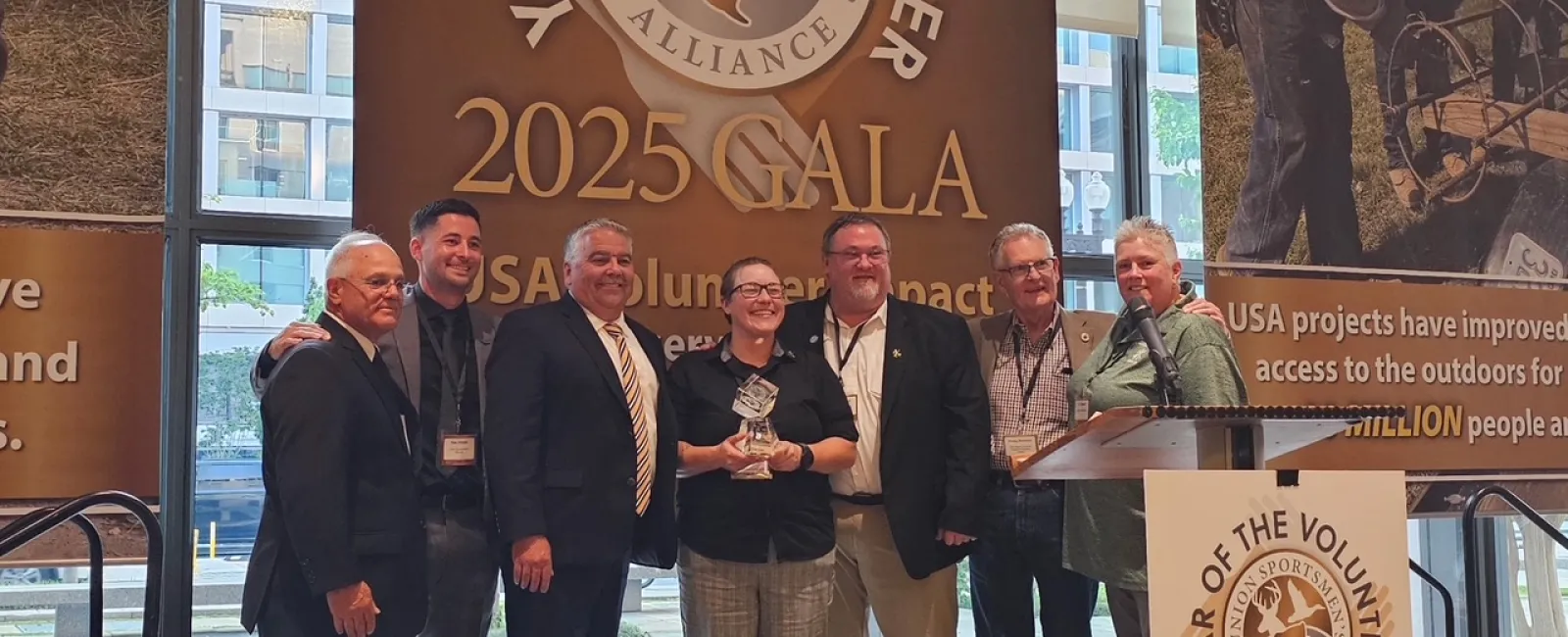 Group of seven people posing with an award at the 2025 Year of the Volunteer Union Sportsmen's Alliance Gala.