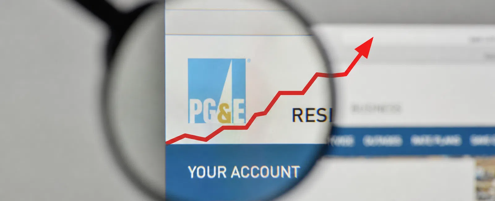 Magnified view of PG&E website showing a rising red arrow graph and account login area.