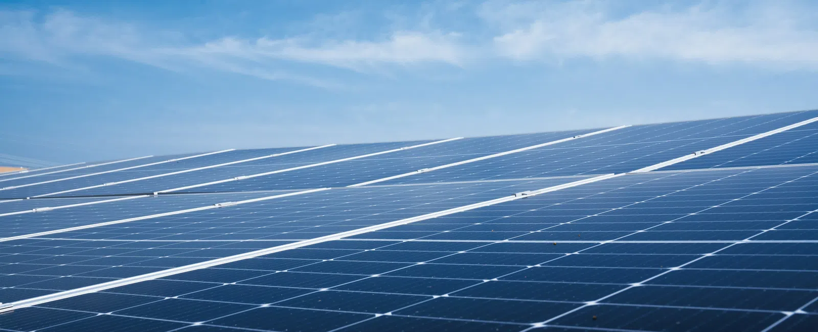 Close-up of solar panels under a bright blue sky capturing renewable energy from sunlight.