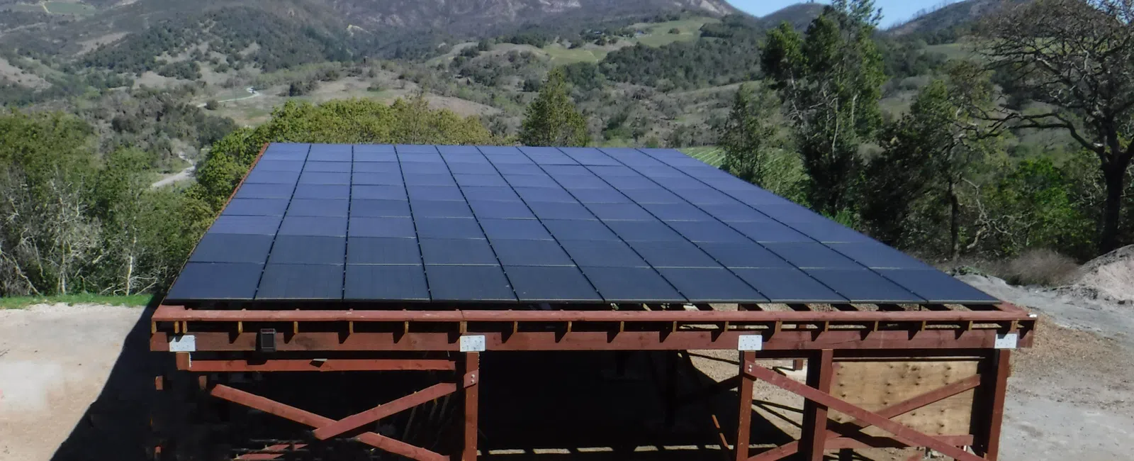 A solar panel installation situated in a mountainous landscape, showcasing renewable energy use in nature.