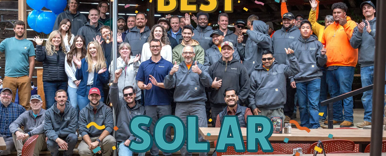 Group photo of North Bay's best solar installers posing outdoors with celebratory text and decorations.