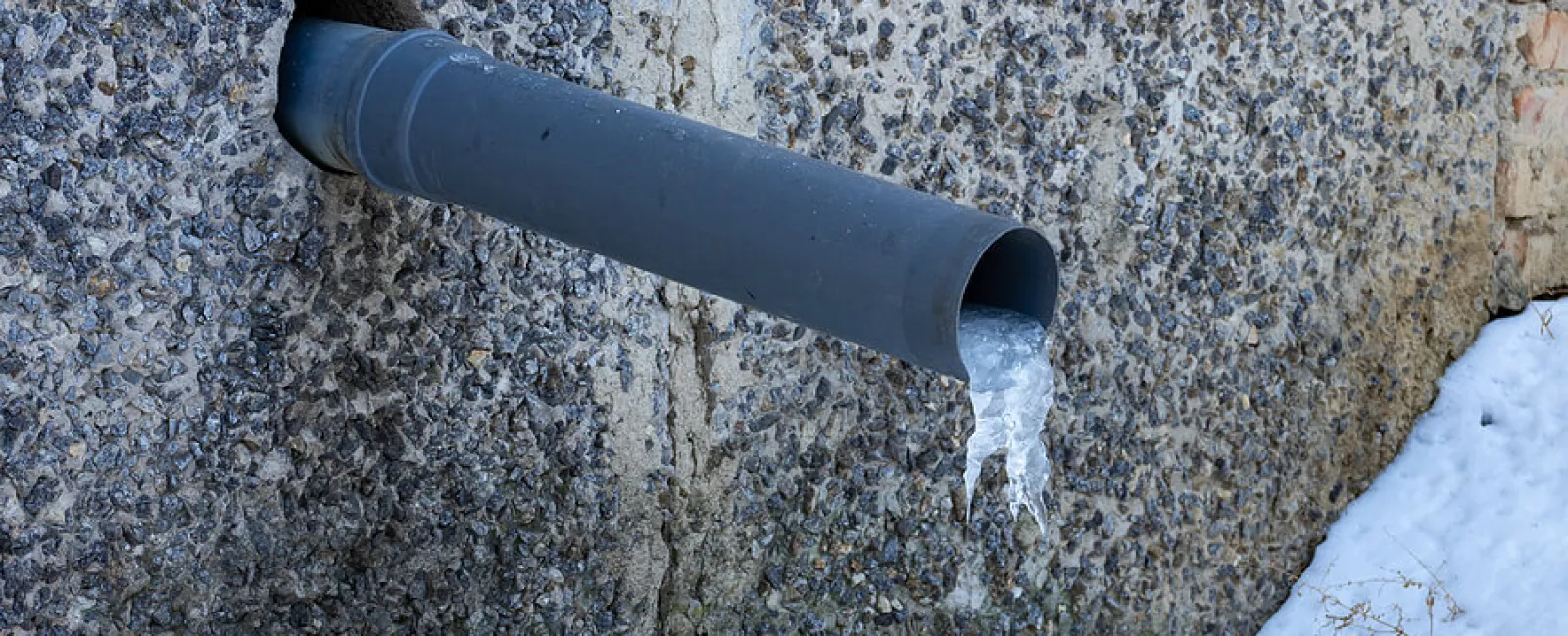 a black and white pipe on a concrete wall
