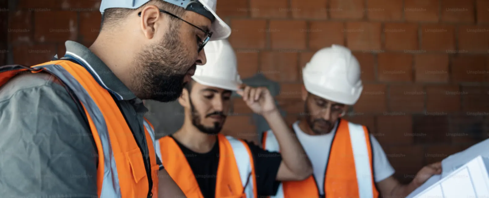 a group of men wearing hardhats and reflectors